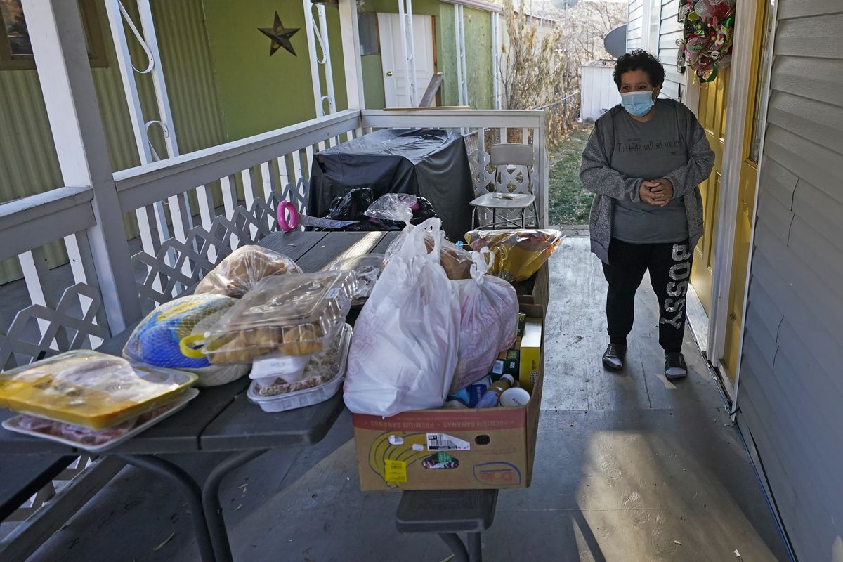 Evelyn Maysonet looks at the food delivery from the Weber-Morgan Health Department Tuesday, Nov. 24, 2020, in Ogden, Utah. Maysonet has been isolating with her husband and son in their Ogden home since all three tested positive for COVID-19 over a week ago. None of them have been able to leave home to buy groceries so Maysonet said they were thrilled to receive the health department’s delivery.  (Rick Bowmer)