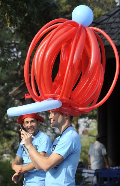 The picture of help: Ryan Oelrich, 30, checks out a cellphone photo of himself taken by Robert Garcia, 21, left, as they wait for the start of the Spokane AIDS Network 2011 Walk from the Riverfront Park north bank shelter on Saturday. Participants were encouraged to don hats, with the best one winning a prize. Oelrich, a balloon artist, created his headwear. Nearly 100 people took part, raising $7,200 to benefit HIV care services and prevention education programs. (Dan Pelle)