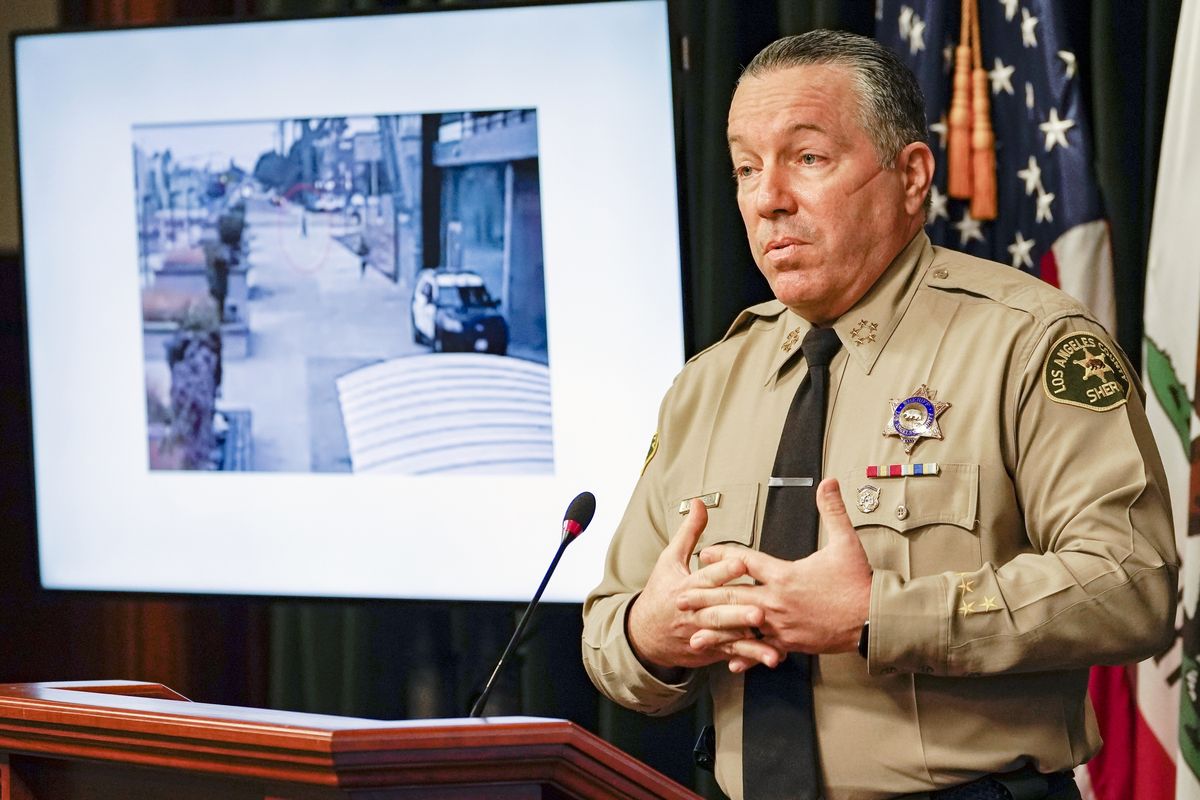 In this Sept. 17, 2020 file photo, Los Angeles County Sheriff Alex Villanueva comments on the investigation of the shooting of two deputies during a news conference at the Hall of Justice in downtown Los Angeles. A photo from surveillance video of the assault is at left. Authorities say they have arrested a man in connection with the shooting of two Los Angeles County sheriff