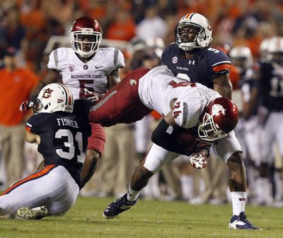 Cougars running back Teondray Caldwell dives for extra yardage over Auburn defensive back Trent Fisher during the second half. (Associated Press)