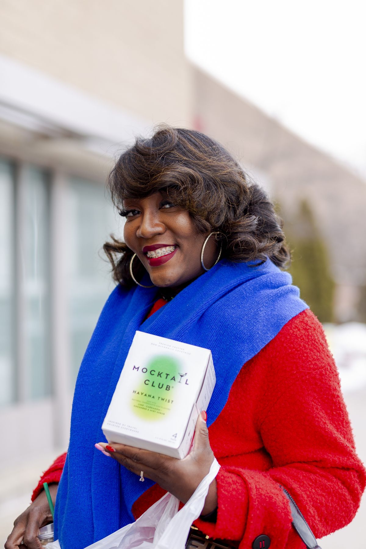 Nikki Penson stands outside a Target in Southfield, Michigan, with a Mocktail Club package. “We wanted to show the power of the Black dollar and encourage Target to reconsider rolling back their DEI policies,” Penson said.  (Sylvia Jarrus/For The Washington Post)