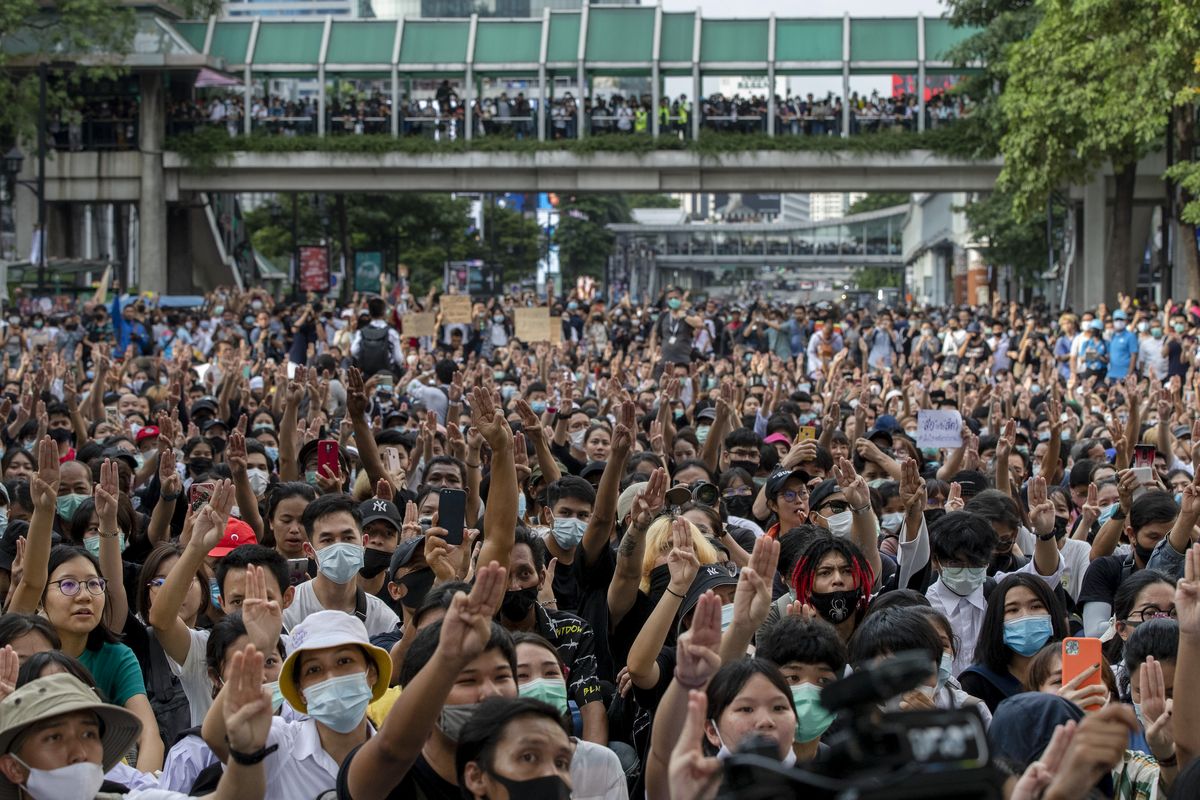 Pro-democracy protesters flash three-fingered salute during a protest as they occupied a main road at the central business district in Bangkok, Thailand, Thursday, Oct. 15, 2020. Thailand