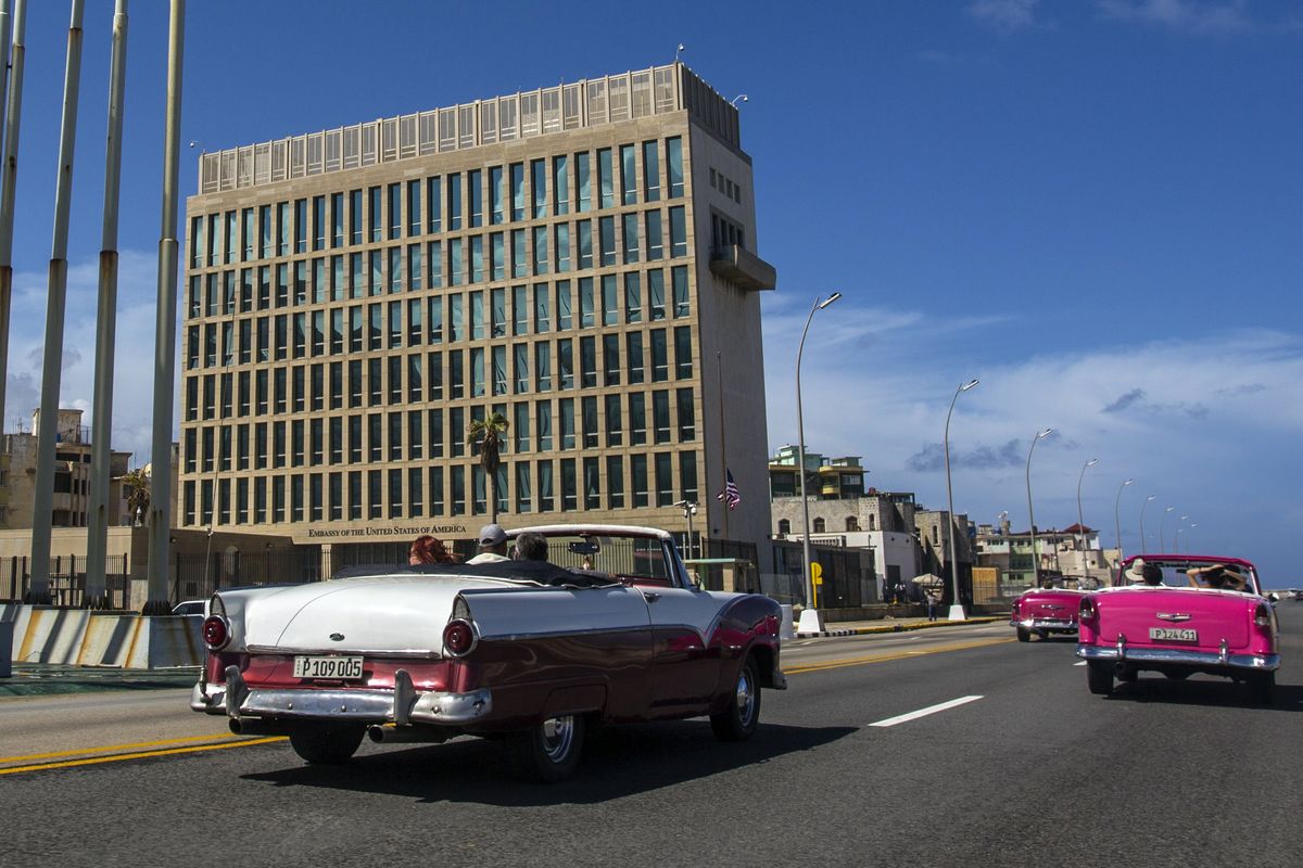 FILE - In this Oct. 3, 2017, file photo, tourists ride classic convertible cars on the Malecon beside the United States Embassy in Havana, Cuba. The Biden administration faces increasing pressure to respond to a sharply growing number of reported injuries suffered by diplomats, intelligence officers and military personnel that some suspect are caused by devices that emit waves of energy that disrupt brain function. The problem has been labeled the “Havana Syndrome,” because the first cases affected personnel in 2016 at the U.S. Embassy in Cuba.  (Desmond Boylan)
