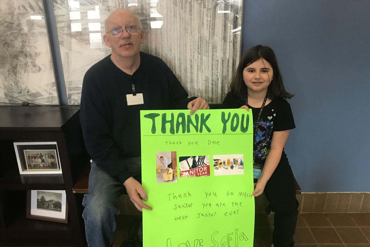 Willard Elementary head custodian Dale Floyd is pictured with third-grader Sofia DeCarlo, who made the thank-you sign they are holding. Dale has been named among four Distinguished Classified Employees for 2019-20 by Spokane Public Schools. (Nina Culver / The Spokesman-Review)