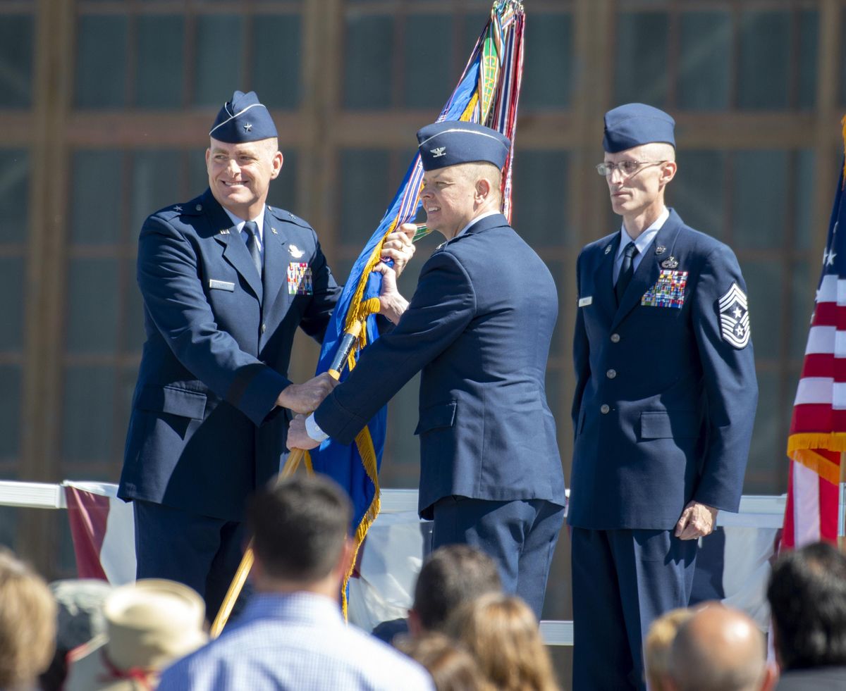 Gen. Darren James, left, passes the guidon, representing the 92nd Air Refueling Wing command, to Col. Derek Salmi, center, to signify Salmis assumption of Fairchild Air Force Base top job Friday, June 15, 2018. At right is Chief MSgt. Lee Mills, the command chief of the 92nd ARW. Salmi takes over from Col. Ryan Samuelson. (Jesse Tinsley / The Spokesman-Review)