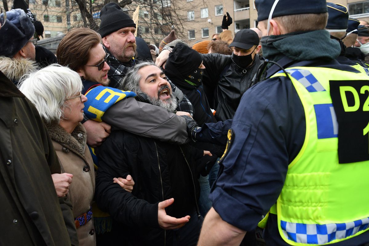 Anti-lockdown protesters face police during a demonstration against the coronavirus restrictions in Stockholm Saturday March 6, 2021. The protest was disbanded by police due to lack of permit for the public gathering.  (Henrik Montgomery)