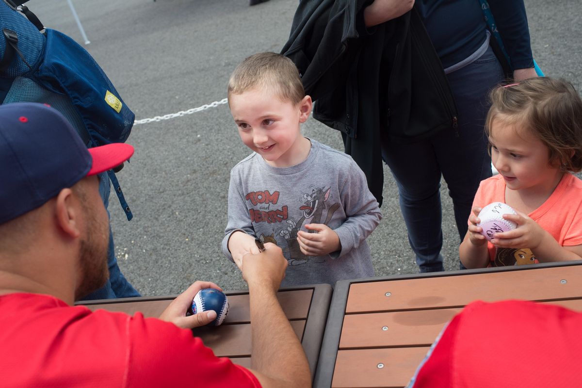 Noah Alves, 5, shakes the hand of pitcher Joe Kuzia after getting a ball signed as Noah’s sister Penny, 3, waits her turn during team’s FanFest last Saturday. (Tyler Tjomsland / The Spokesman-Review)