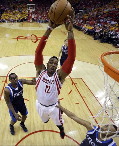 Dwight Howard, center, dunks in Rockets’ 103-94 win over Dallas. (Associated Press)