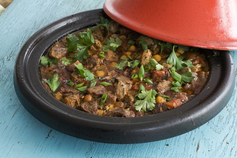 Rosemary lamb tagine with chickpeas and tomatoes is cooked on the stove using a tagine. The conical lid allows steam to gather and drip down into the food. (Associated Press)