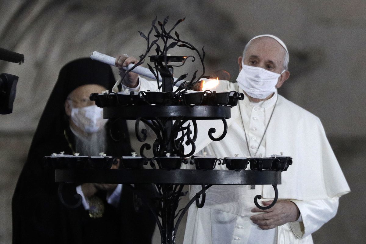 Pope Francis lights a candle for peace Tuesday during a ceremony in the square outside Rome’s City Hall. (Gregorio Borgia)