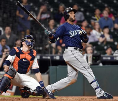 Robinson Cano of the Mariners watches his go-ahead home run off Astros relief pitcher Luke Gregerson during the 11th inning of Monday night’s game in Houston. (Eric Christian Smith / Associated Press)