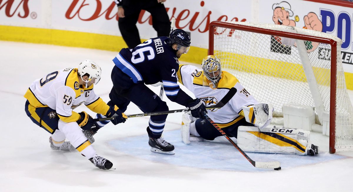 In this March 25, 2018, file photo, Nashville Predators’ Roman Josi (59) tries to stop Winnipeg Jets’ Blake Wheeler (26) as he gets a scoring attempt on goaltender Juuse Saros (74) during the overtime period of NHL hockey action in Winnipeg, Manitoba. The Predators take on the Jets in the Western Conference semifinals beginning Friday, April 27, at Nashville. (Trevor Hagan / Canadian Press via AP)