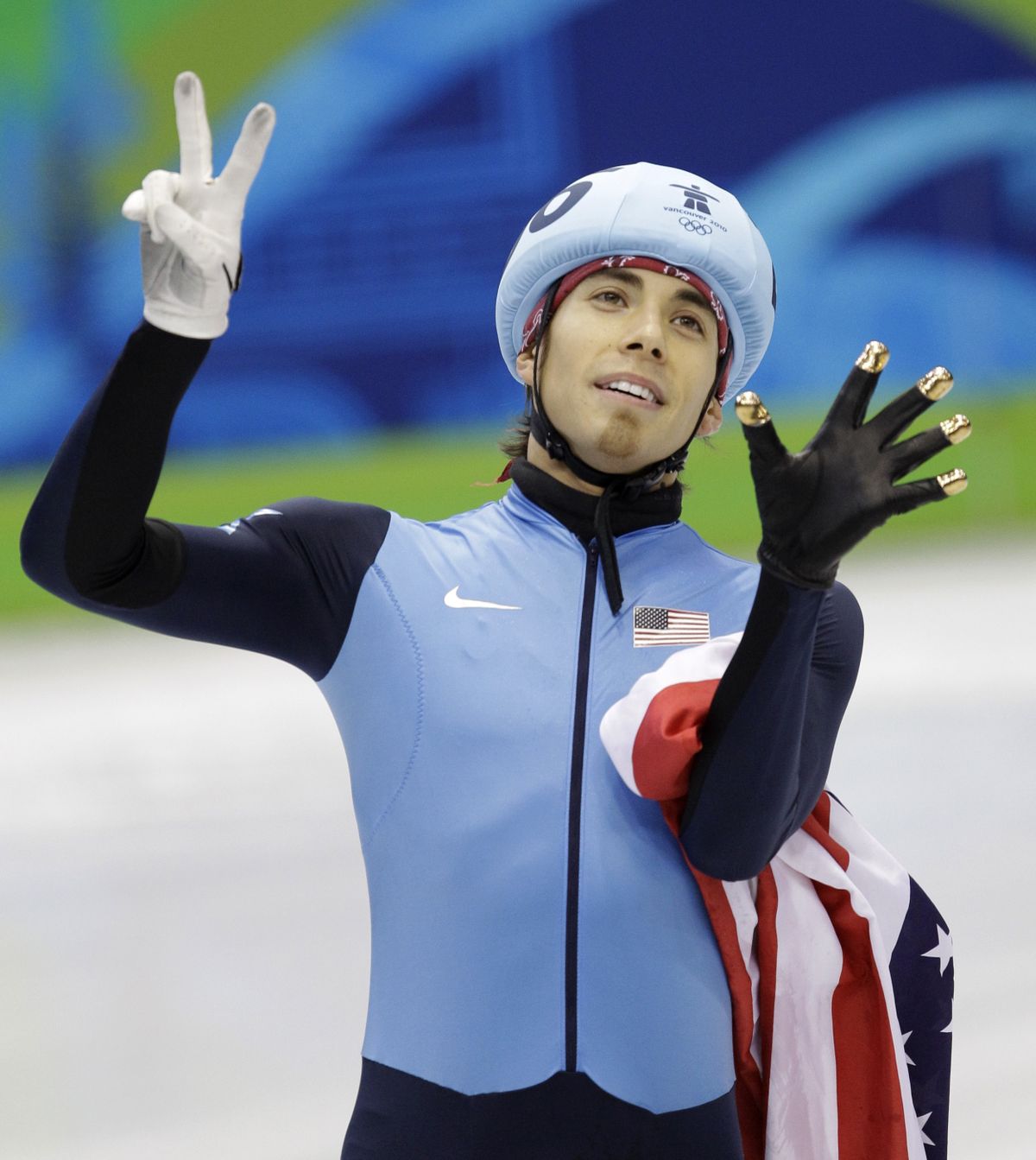 Apolo Anton Ohno holds up seven fingers, the number of medals he’s won, after Saturday’s bronze finish.  (Associated Press)