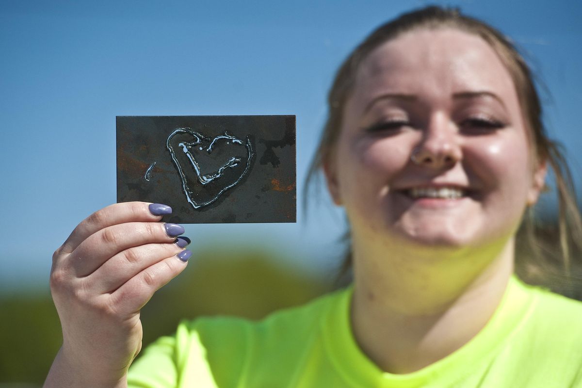 East Valley High School senior Emily Clarke shows of the result of her plasma cutting skills during the Community Colleges of Spokane’s Pizza, Pop and Power Tools event at the Apprenticeship and Journeyman Training Center in Spokane on Tuesday, April 30, 2019. (Kathy Plonka / The Spokesman-Review)