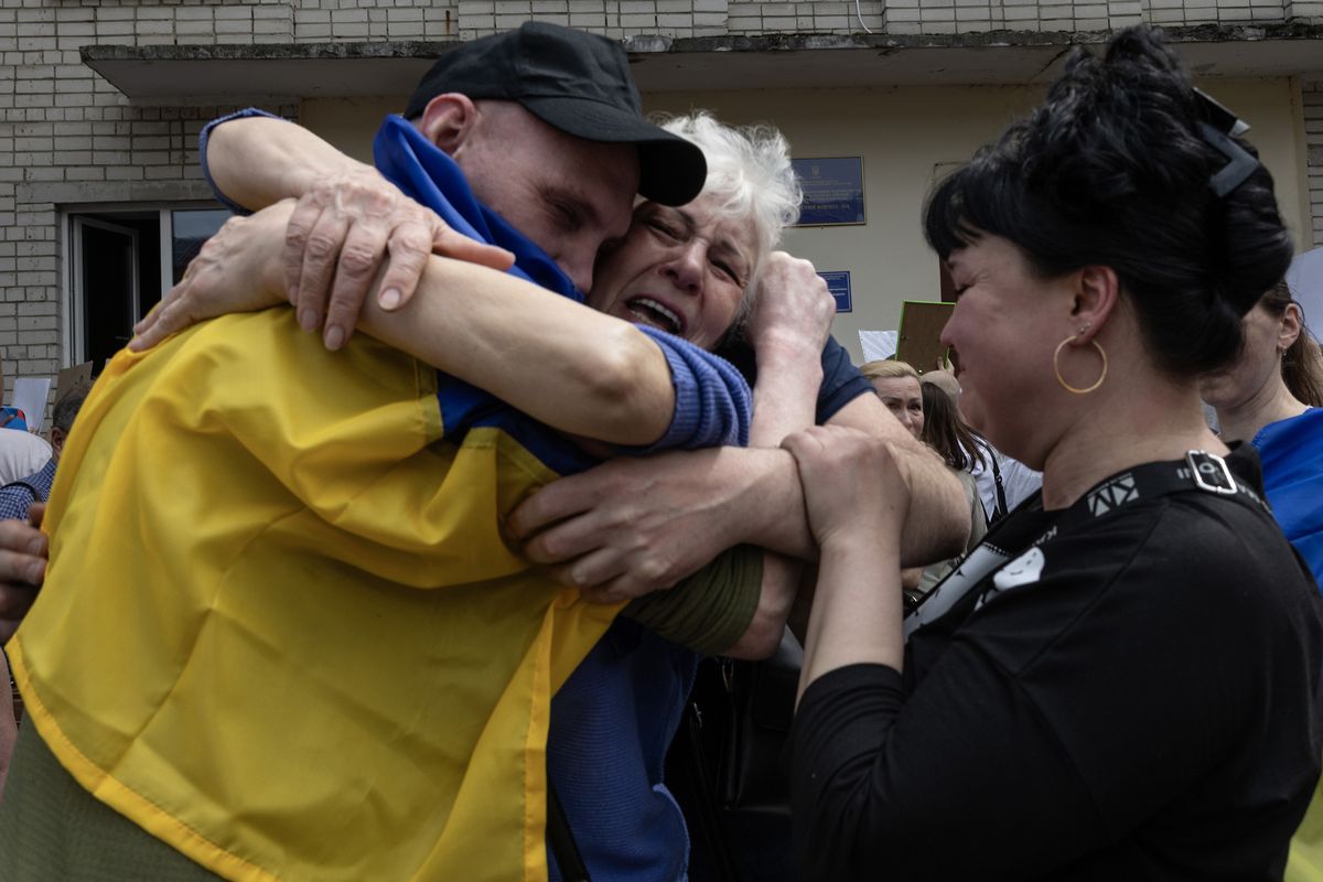 Ukrainian families of prisoners of war embrace each other after finally meeting their loved ones on Sunday in Chernihiv, Ukraine.  (Paula Bronstein/Getty Images North America/TNS)