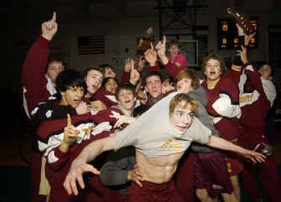 
The University High wrestling team celebrates their 36-19 victory over defending champs East Valley High Saturday night during the GSL Champion Match.
 (Liz Kishimoto photos/ / The Spokesman-Review)