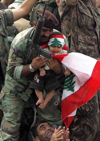 
A soldier holds a child wearing the Lebanon flag as a headband as they celebrate the end of fighting in the Nahr el-Bared Palestinian refugee camp on Monday.Associated Press
 (Associated Press / The Spokesman-Review)