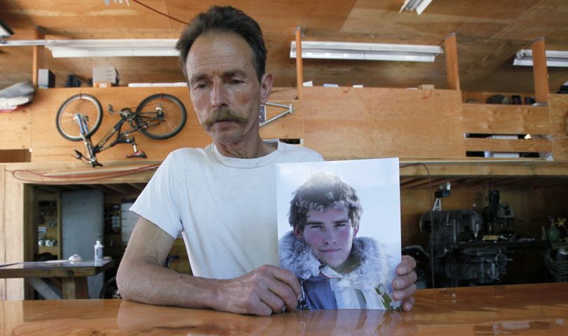 In this June 1, 2009 photo, Lou  Brown holds a photo of his son,  Sam Lindsay- Brown in his machine shop in Revelstoke, BC.  Sam Lindsay- Brown was a helicopter pilot and smuggler of drugs that he took from Canada in to the U.S. before being arrested in Ione, Wash., in February of 2009. He committed suicide while in custody. (AP Photo/Elaine Thompson) (Associated Press)