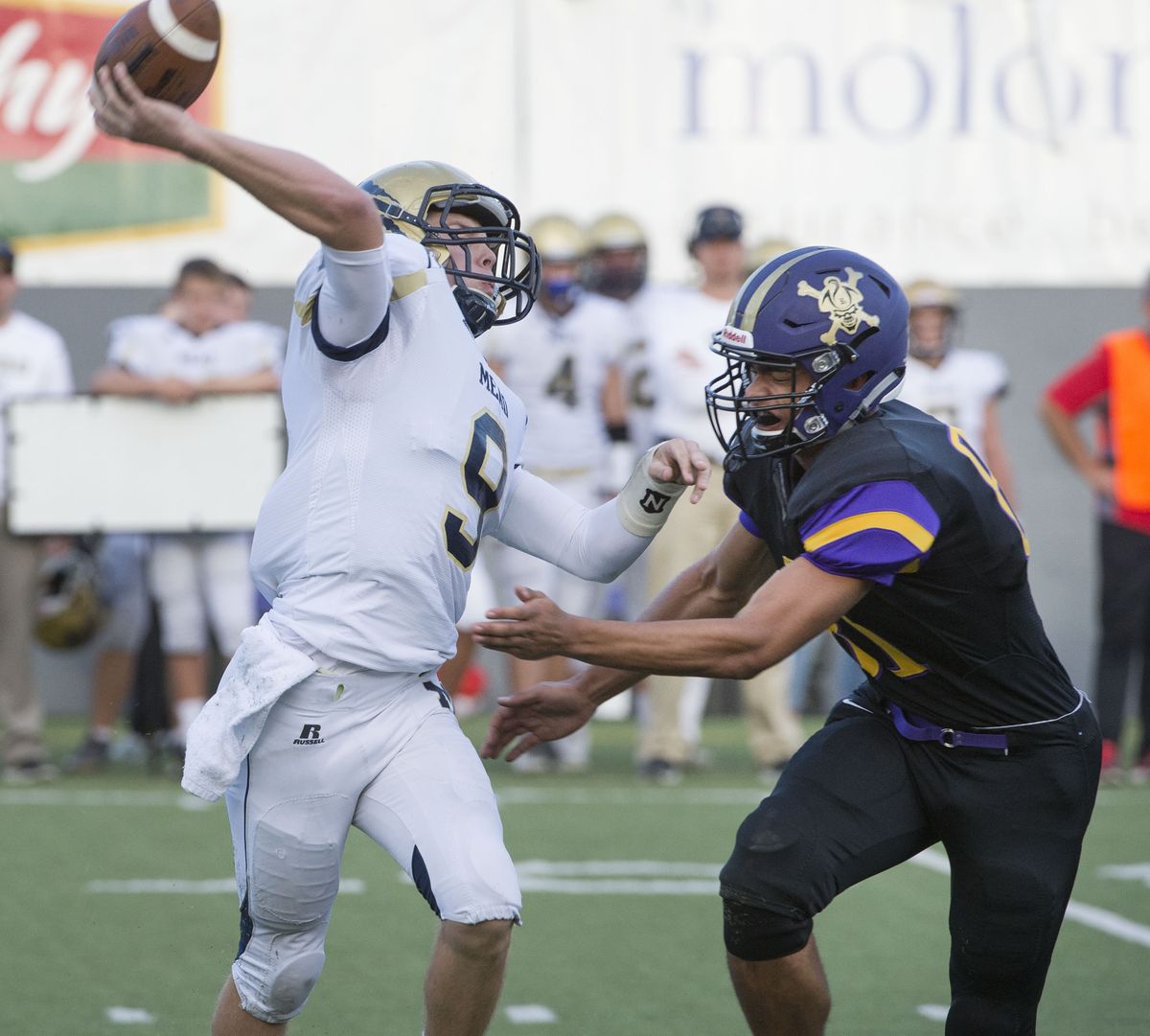 Mead quarterback Thomas Dammarell is pressured into a hurried throw by Rogers’ Jesse Bonasera. (Dan Pelle)