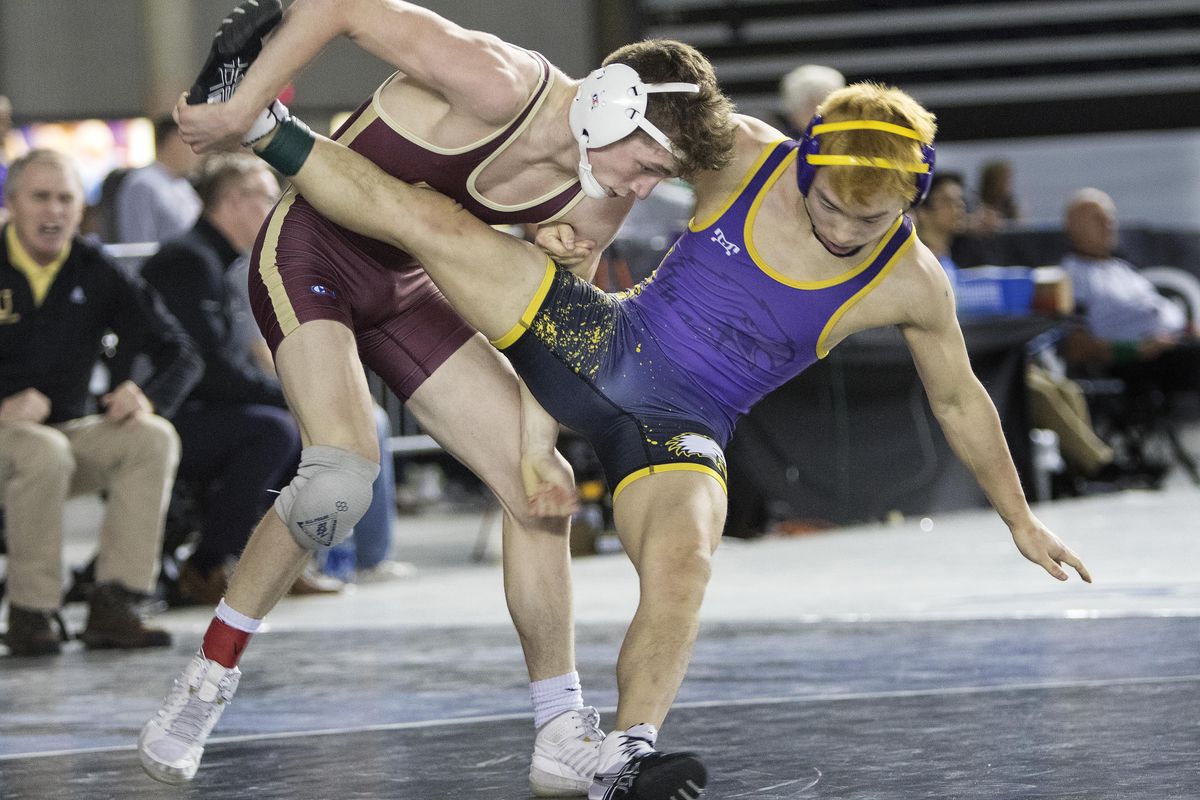 University’s Drew Roberts, left, controls the fall of Issaquah’s Thomas Brown as he gets a takedown during their 126-pound match in Mat Classic XXXI in Tacoma on Friday. Roberts won the match 16-0. (Patrick Hagerty / For The Spokesman-Review)