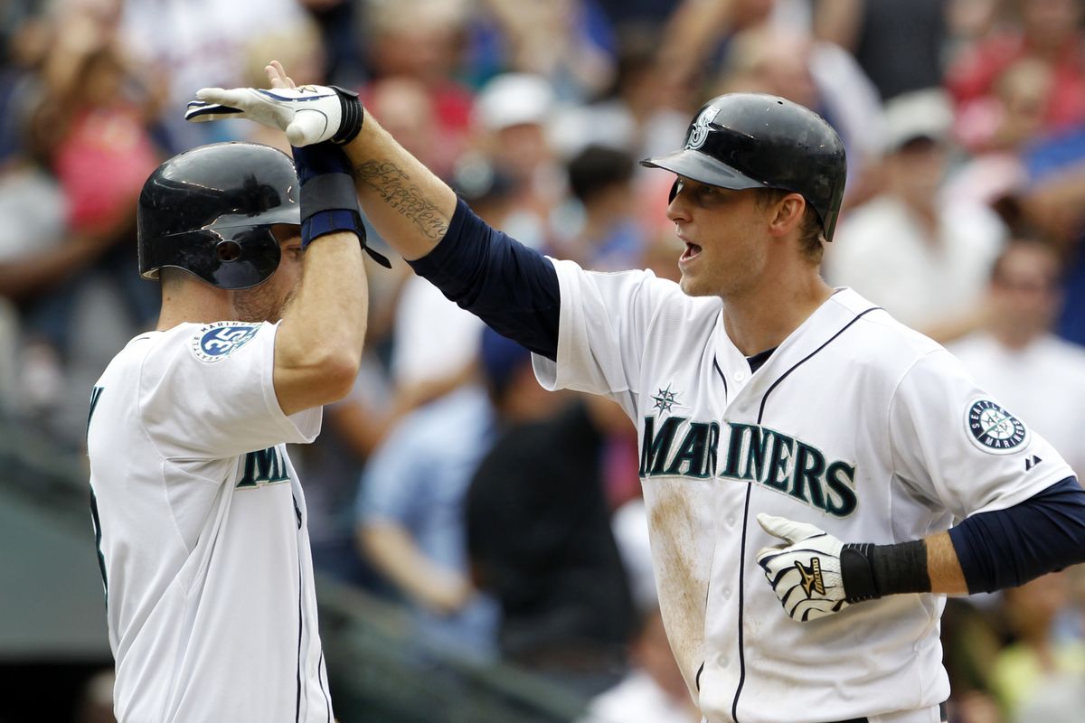 Dustin Ackley, left, congratulates Mariners teammate Michael Saunders on his two-run home run in the seventh inning. (Associated Press)