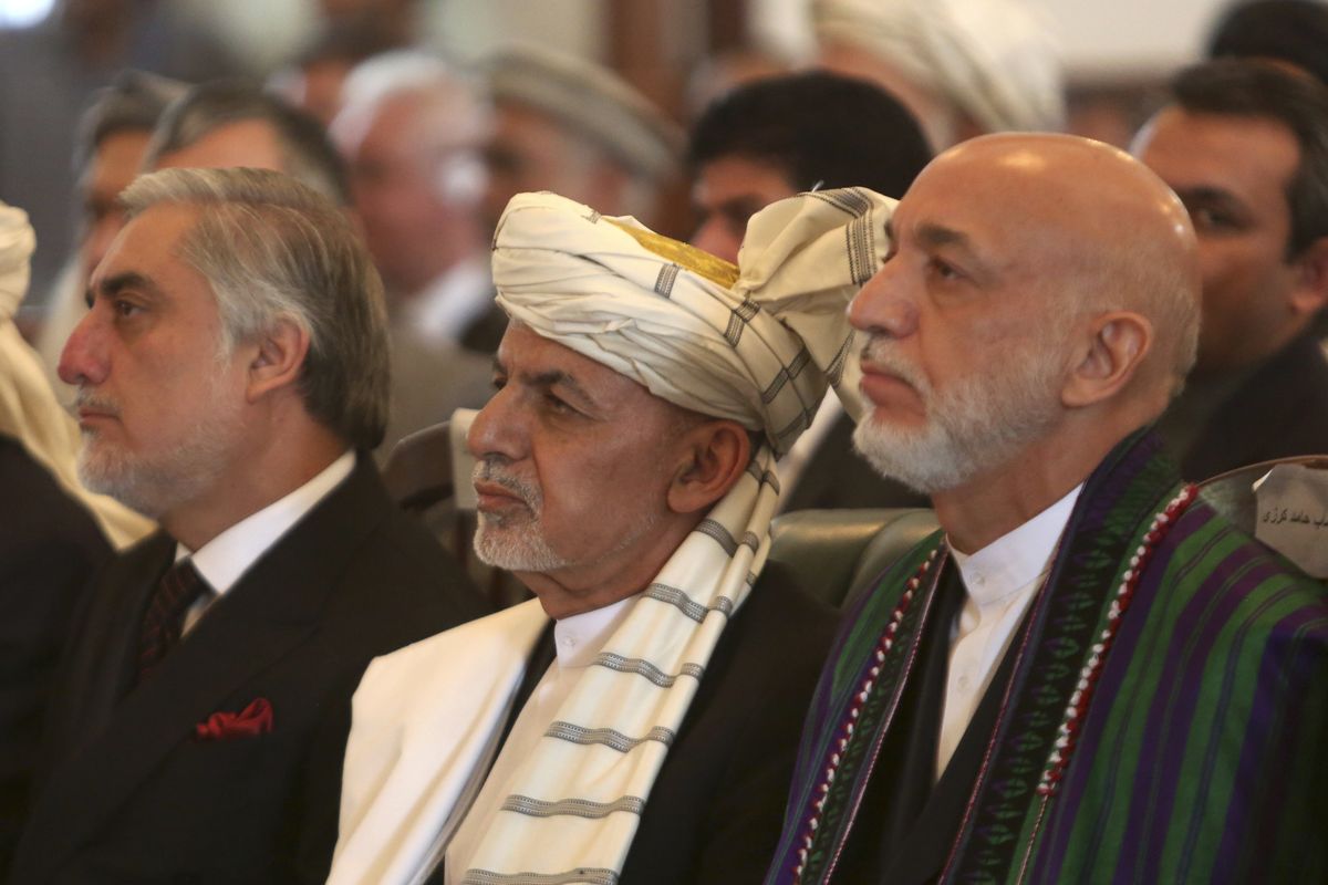 FILE - In this Sept. 29, 2020, Afghan President Ashraf Ghani, center, former President Hamid Karzai, right, and Chief Executive Abdullah Abdullah, left, watch the live broadcast of Gulbuddin Hekmatyar after the signing of a peace treaty at the presidential palace in Kabul, Afghanistan. Officials on both sides of Afghanistan