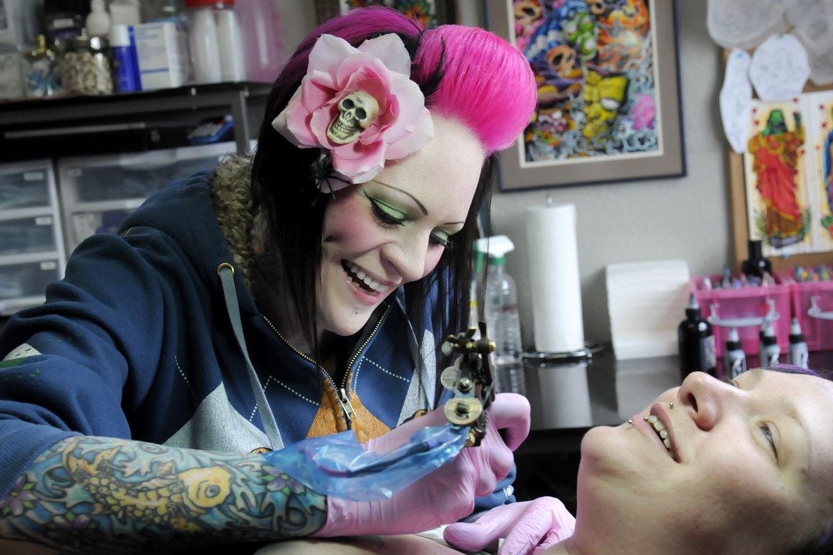 Tattoo artist Jeanie Newby chats while she gives Stephanie Goldsmith a tattoo on her collar bone.  Newby will attend the Lilac City Tattoo Expo and will be selling acrylic and watercolor art and handmade hair clips like the flower she’s wearing.jesset@spokesman.com (Jesse Tinsley)