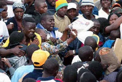 
Crowds waiting to travel home jostle for space on the few buses available due to a shortages of fuel in Harare in this May 20 photo. The government vowed Tuesday to demolish squatter shacks in a 
