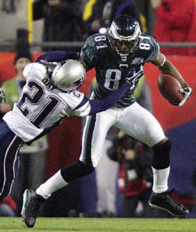
Eagles receiver Terrell Owens is brought down after a catch by Patriots cornerback Randall Gay.  
 (Associated Press / The Spokesman-Review)