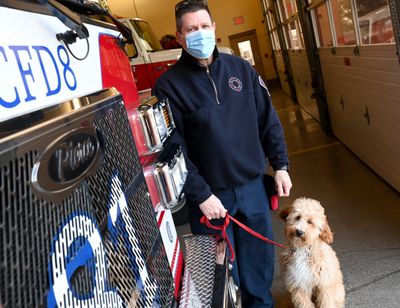 Aaron McNally, chaplain for Spokane County Fire District 8, poses for a photo with therapy dog Pierce, who is named after the Pierce fire engine manufacturer, on Saturday at Station 81.  (Tyler Tjomsland/The Spokesman-Review)