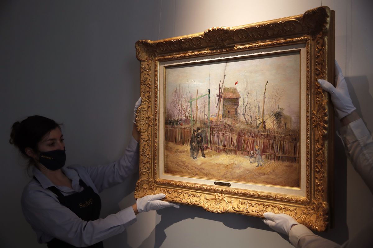 Sotheby’s personnel display of “Scene de rue à Montmartre” (Street scene in Montmartre), a painting by Dutch master Vincent van Gogh, on Thursday at Sotheby’s auction house in Paris.  (Christophe Ena)
