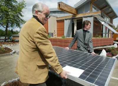 
Mike Nelson, director of Northwest Solar Center, and Mat Taylor, professor of architecture and construction management at Washington State University, carry a solar panel into place in front of The Zero Energy House at Shoreline Community College this month.  
 (Paul Joseph Brown Seattle Post-Intelligencer / The Spokesman-Review)
