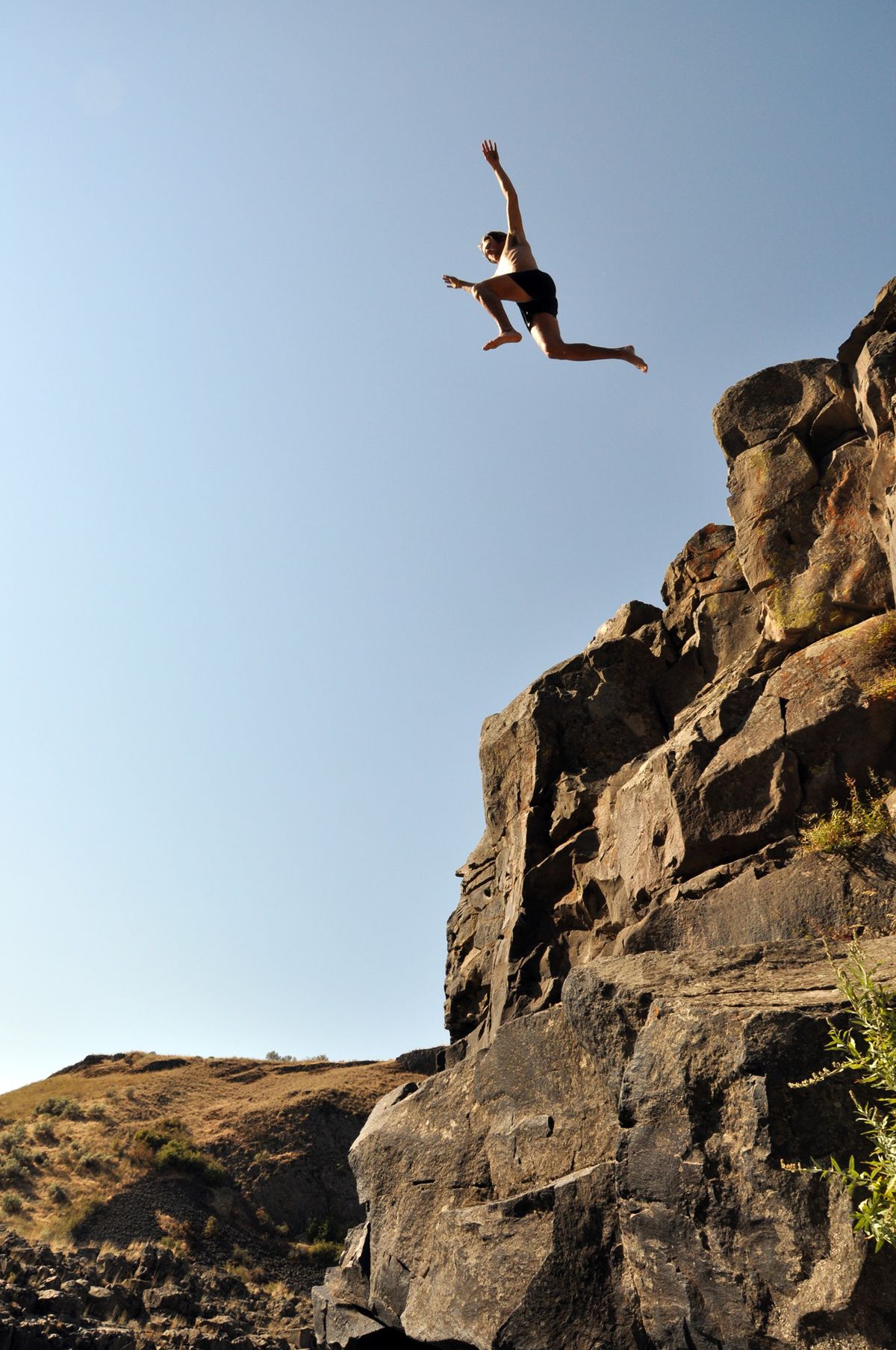 With the sun intensifying, Whitman College student Curtis Reid cools off with a leap to the river pool upstream from Palouse Falls. (Rich Landers / The Spokesman-Review)