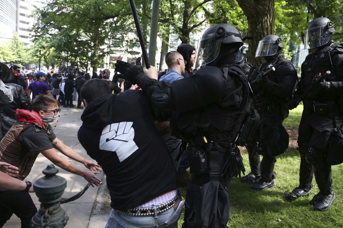 Police officers move to clear demonstrators from Chapman Square, near City Hall in downtown Portland, declaring it an unlawful assembly,  June. 4, 2017. (Dave Killen / Associated Press)