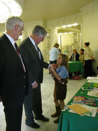 Reps. Ron Mendive, R-Coeur d'Alene, left, and Lance Clow, R-Twin Falls, talk to Brownie Ella Marcum-Hart, 9, Monday in the state Capitol. (Betsy Russell)
