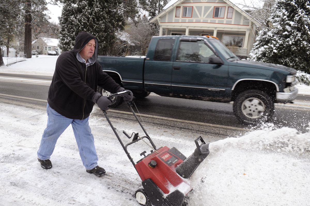 Gary Taitch removes snow from a neighbor