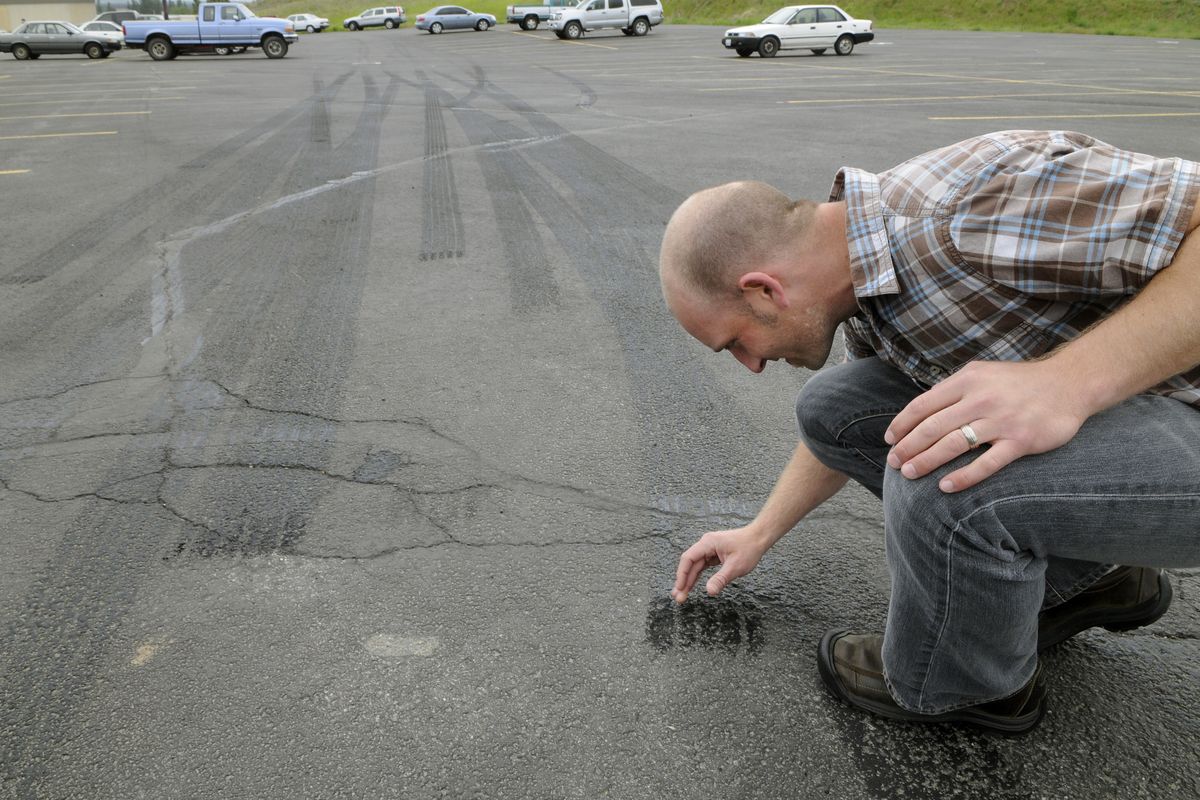 Eastern Washington University student Shaun Kim checks the skid marks made from a Spokane County Sheriff’s Office patrol car during a test in a campus parking lot. Funded by the Sheriff’s Office, the mechanical engineering students were testing an accelerometer they designed and built. (Dan Pelle)