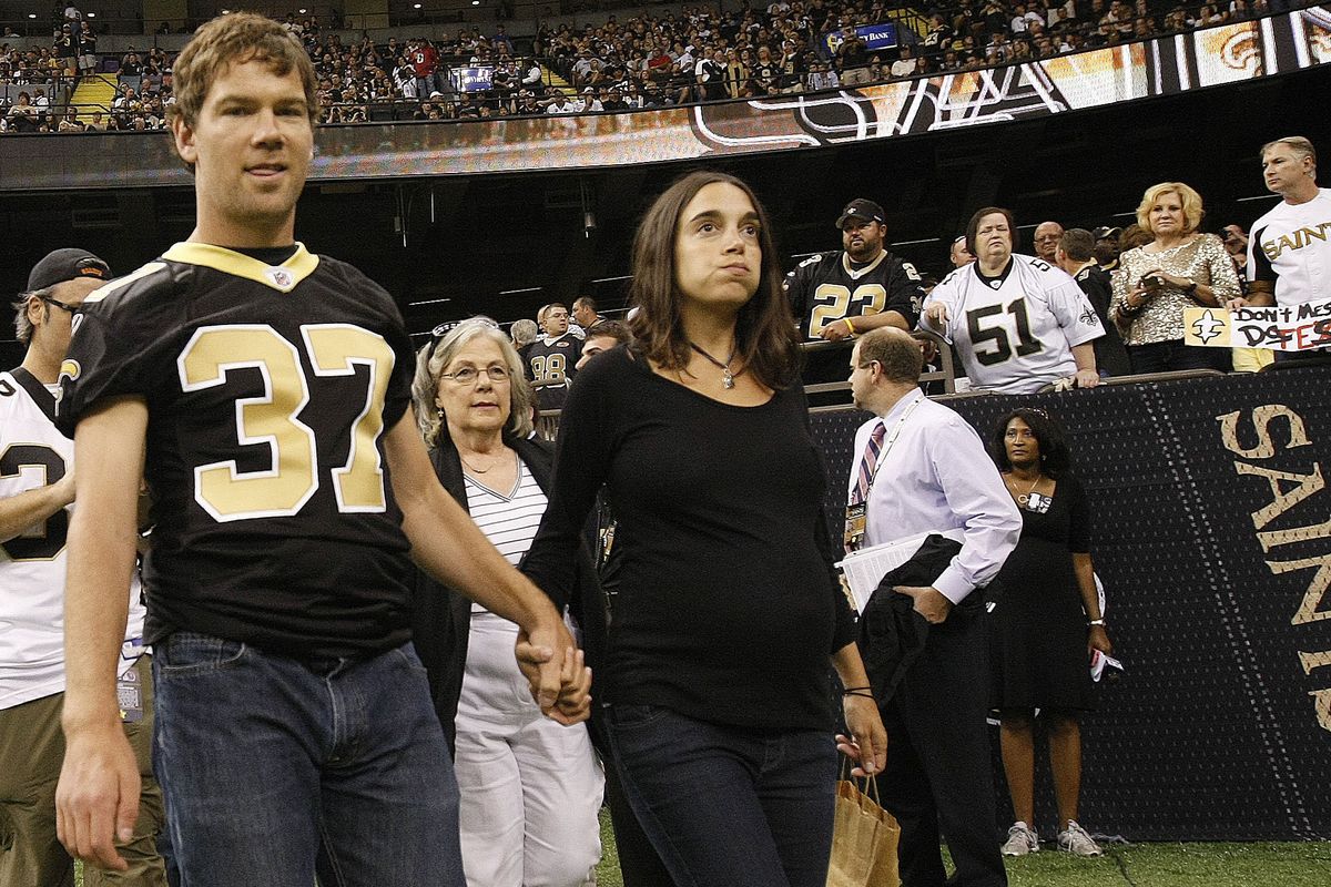 Steve Gleason and his wife, Michel, walk onto the field at the Superdome. (Associated Press)