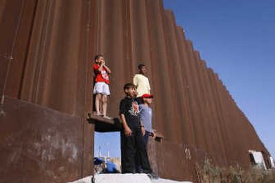 
The wall separating the Gaza Strip from Egypt dwarfs Palestinian children from the Rafah refugee camp on Friday. Associated Press
 (Associated Press / The Spokesman-Review)