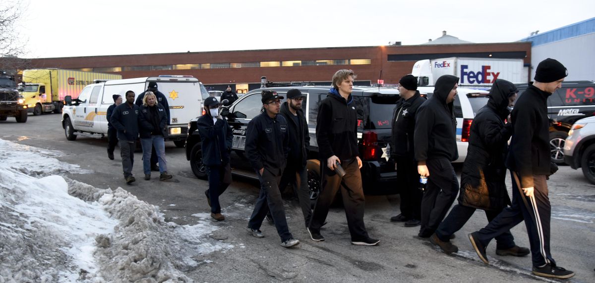 Employees are escorted from the scene of a shooting at a manufacturing company, Friday, Feb. 15, 2019, in Aurora, Ill, that police said left several people dead and several police officers wounded. (Matt Marton / Associated Press)