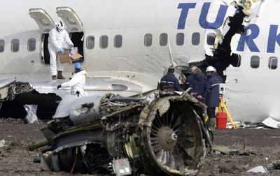 Crash investigators on Thursday examine the wreckage of the Turkish Airlines Boeing 737 that crashed the previous day while approaching Amsterdam’s Schiphol Airport.  (Associated Press / The Spokesman-Review)