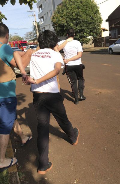 In this photo provided by the news site Guiamedianeira, police take two students into custody after one of them opened fire on students at a school, in Medianeira, Parana state, Brazil, Friday, Sept.28, 2018. A teenager opened fire leaving two students injured, authorities said. In a statement, the state’s secretary of education said the shooter and another teen who was with him had been taken into custody. (Arildo Kehl / AP)