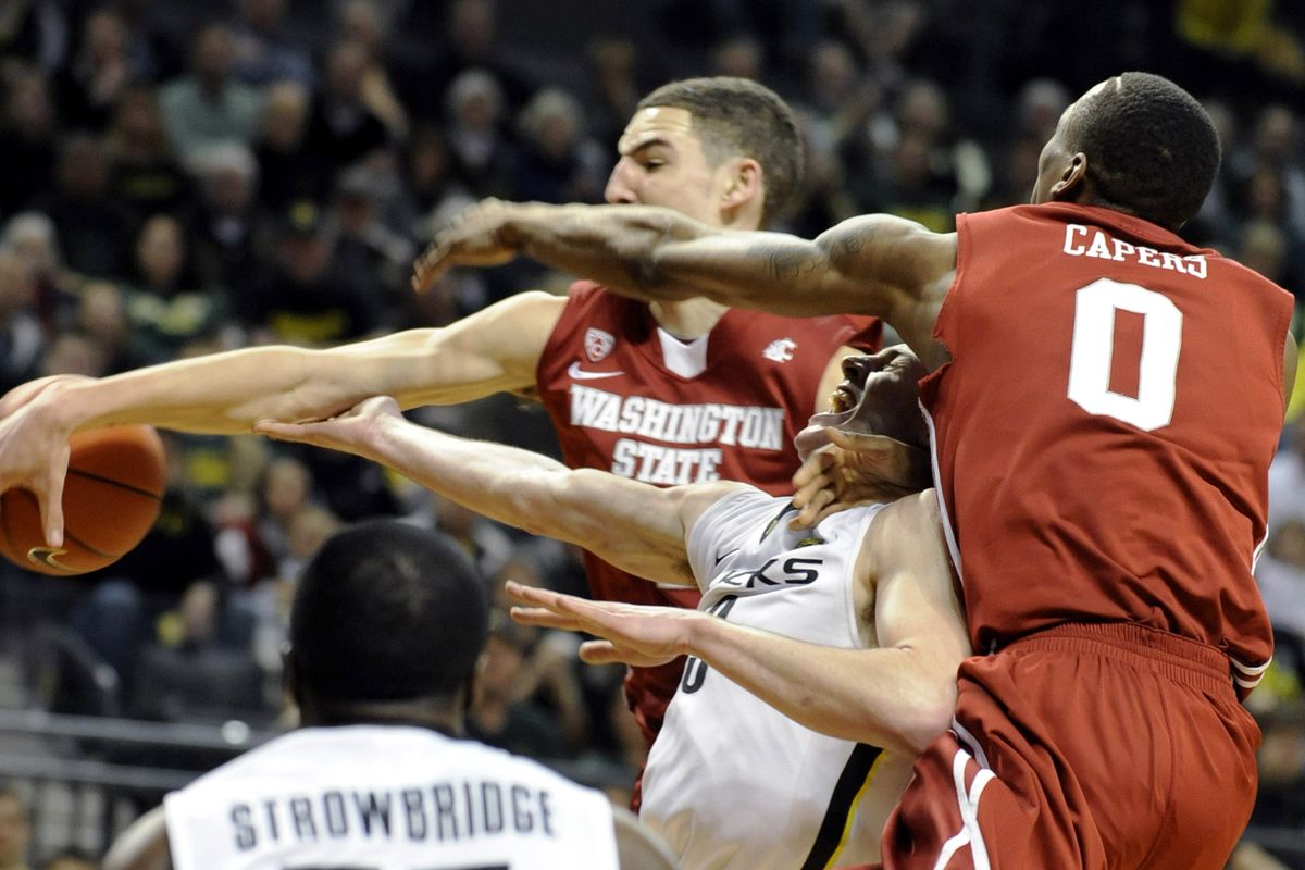 Washington State’s Klay Thompson, left, and Marcus Capers hammer Oregon’s Garrett Sim during the second half. (Associated Press)