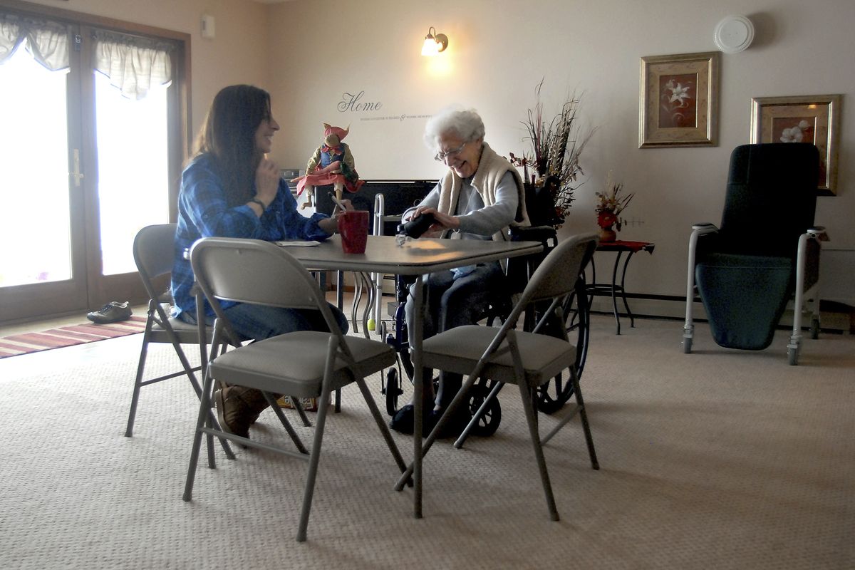 Donna Redmond, left, plays a dice game with Margaret Cripe in a common room  at Expressions Specialized Memory Care Home in Columbia Falls, Mont., on Jan. 5.  (Associated Press)