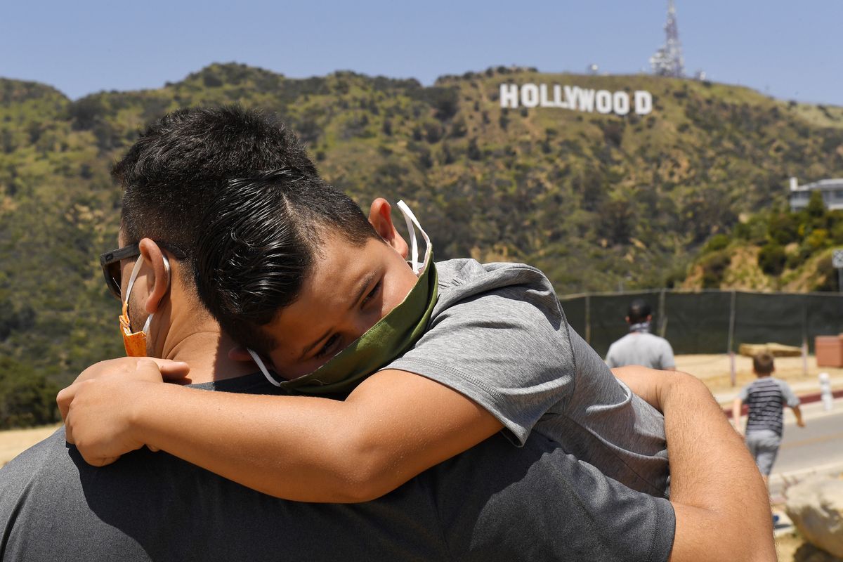 A father holds his son on May 15 near the famed Hollywood sign during the coronavirus outbreak in Los Angeles.  (Mark J. Terrill)