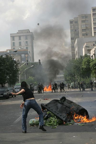 Supporters of opposition leader Mir Hossein Mousavi set fire to a barricade as they hurl stones during a protest in Tehran, Iran, on Saturday.  (Associated Press / The Spokesman-Review)