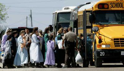 
Law enforcement officials assist members of the Fundamentalist Church of Jesus Christ of Latter Day Saints onto a school bus in Eldorado, Texas, on Sunday. Associated Press
 (Associated Press / The Spokesman-Review)