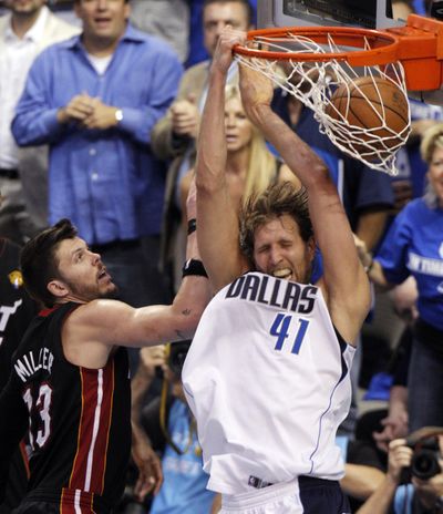 Miami’s Mike Miller watches as Dirk Nowitzki dunks for the Mavericks during the second half Thursday. (Associated Press)