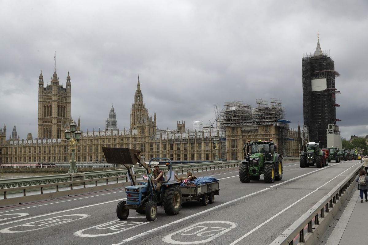 Farmers from the group Save British Farming drive tractors across Westminster Bridge, backdropped by the Houses of Parliament and the scaffolded Big Ben tower in London, in a protest against cheaply produced lower standard food being imported from the U.S. after Brexit that will undercut them, Wednesday, July 8, 2020.  (Matt Dunham)