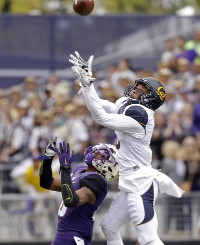 Cal's Darius White leaps above Marvin Hall for an interception, one of the Huskies’ five turnovers. (Associated Press)